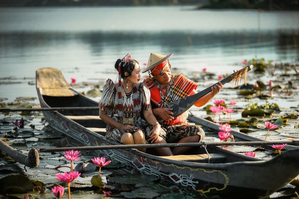 canoe, traditional clothing, musician, paddling, asian culture, lotus flower, traditional musical instrument, people in boat, lake, water plants, culture, art, romantic scene, indigenous, cooperation, nature, traditional craft, floating flowers, handmade, outdoor life